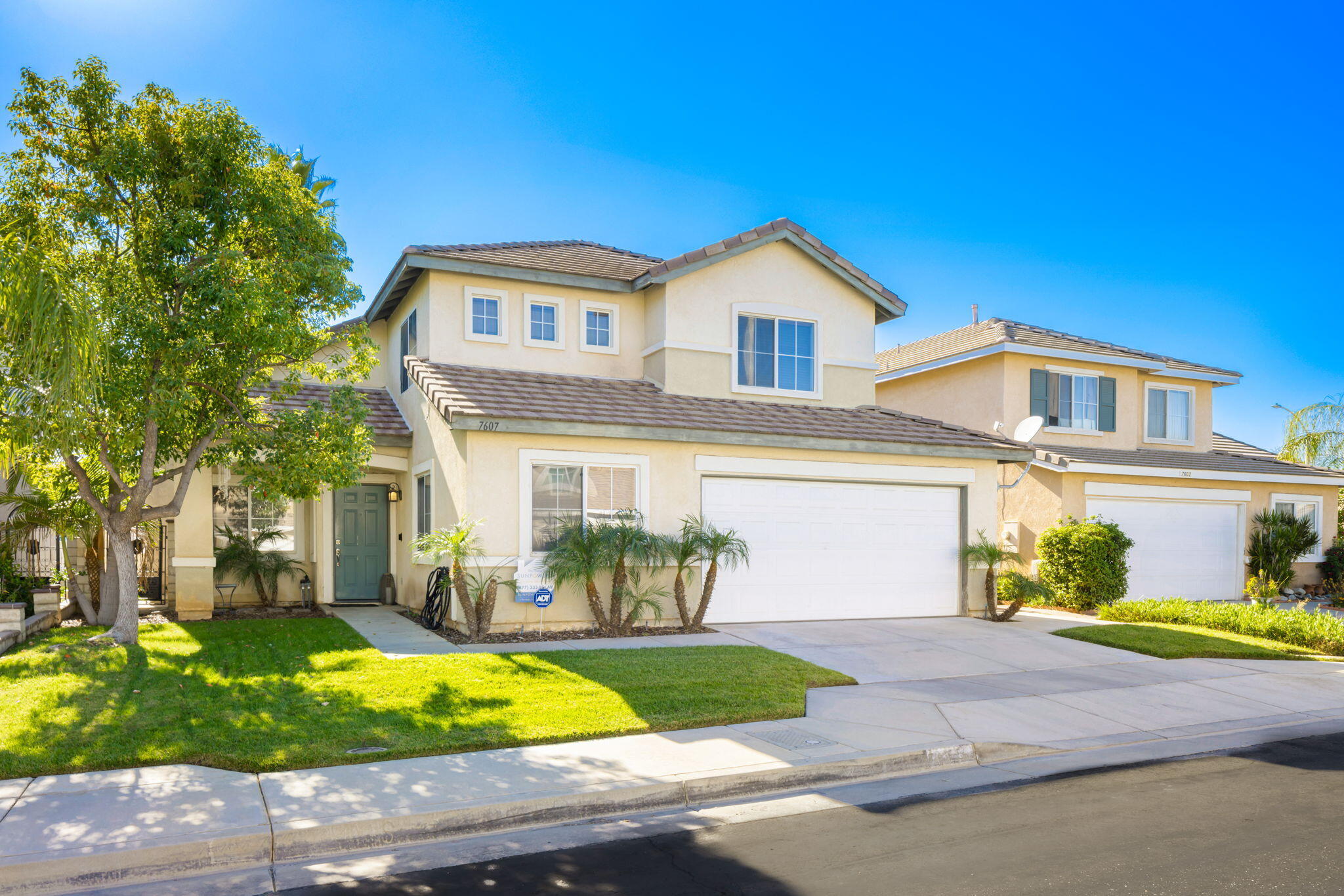 7607 Canberra Way Riverside, CA 92508 - Photo 3 of 28 a front view of a house with a yard and garage