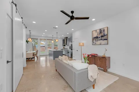 a living room with furniture and a view of kitchen