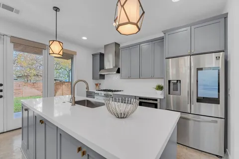 a kitchen with kitchen island a counter space a sink appliances and cabinets