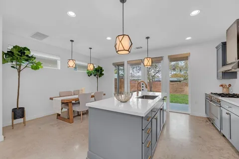 a large kitchen with stainless steel appliances a large center island attached withe living room