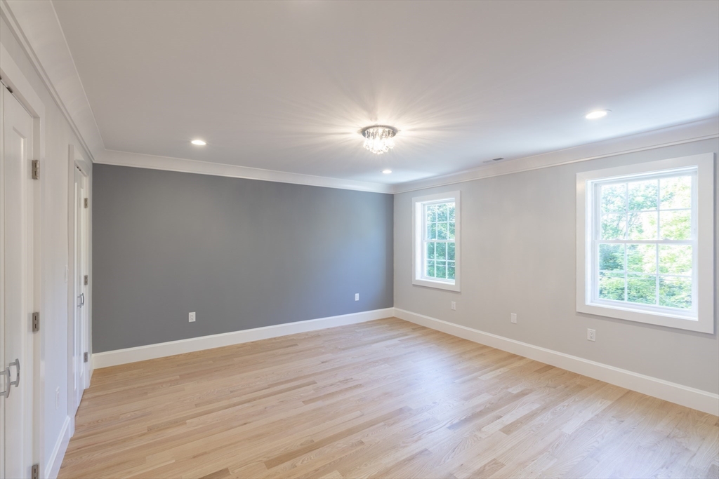 239 Hardy Pond Road Waltham, MA 02451 - Photo 17 of 28 an empty room with wooden floor and windows