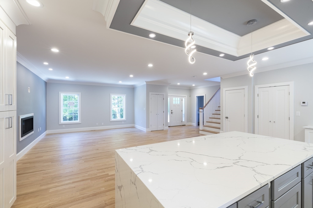239 Hardy Pond Road Waltham, MA 02451 - Photo 7 of 28 a large white kitchen with wooden floor and a refrigerator