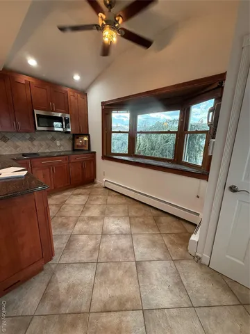 a large kitchen with stainless steel appliances granite countertop a stove a sink and a microwave