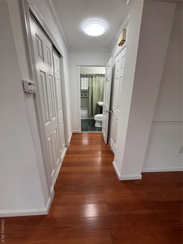 a view of a hallway with wooden floor and staircase