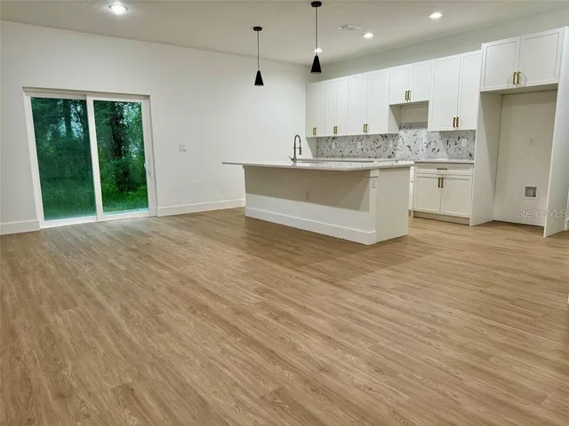 a view of kitchen with stainless steel appliances granite countertop a stove a sink and a refrigerator