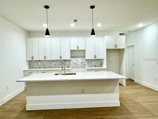 a view of kitchen with stainless steel appliances granite countertop cabinets and wooden floor