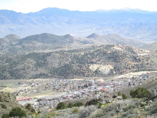 a view of a dry yard with mountains in the background