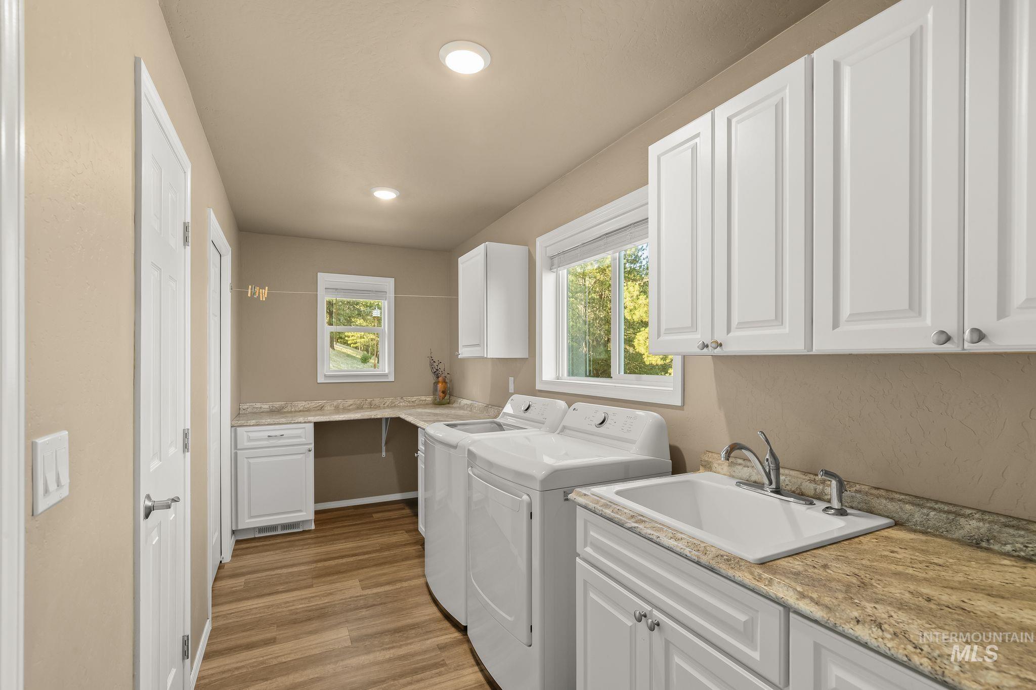 435 River Pointe Lane Lenore, ID 83541 - Photo 12 of 50 Laundry area featuring wood-finish flooring, recessed lighting, and white shaker-style cabinetry