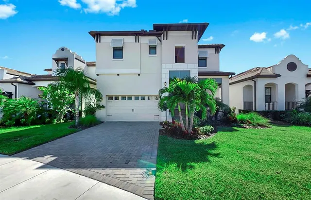 a view of a house with a yard and potted plants