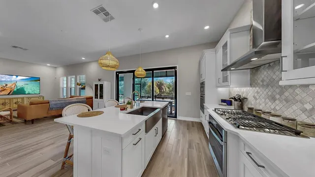 a kitchen with a sink stove and wooden floor