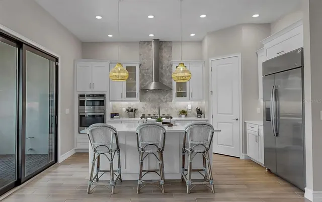 a kitchen with stainless steel appliances kitchen island granite countertop a refrigerator and microwave