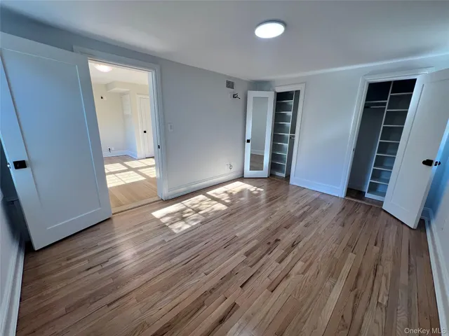 an empty room with wooden floor and closet