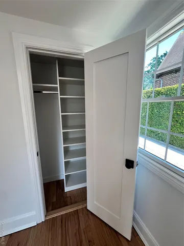 a view of walk in closet with empty racks