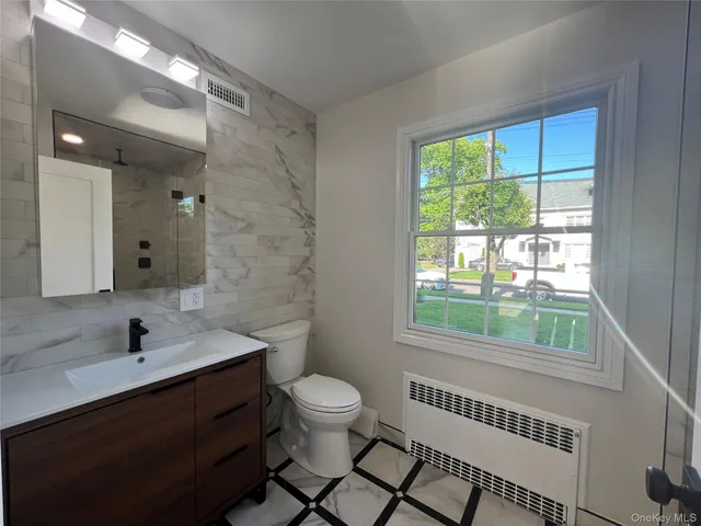 a bathroom with a sink a toilet and a window