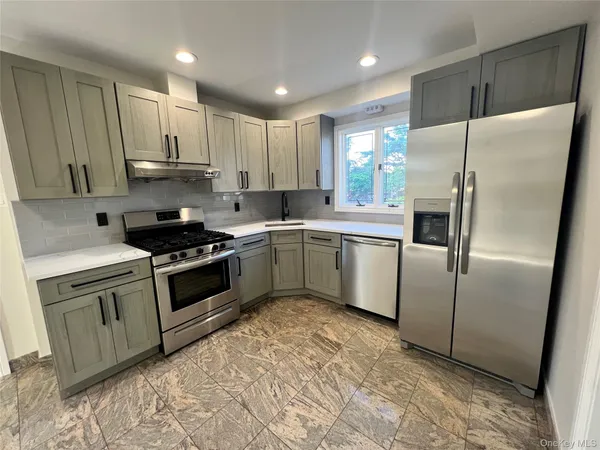 a kitchen with granite countertop a sink stove and refrigerator