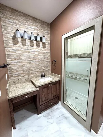 a bathroom with a granite countertop sink and shower