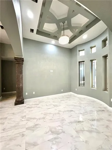 a view of an empty room with a chandelier fan