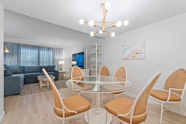 a dining room with furniture a chandelier and wooden floor