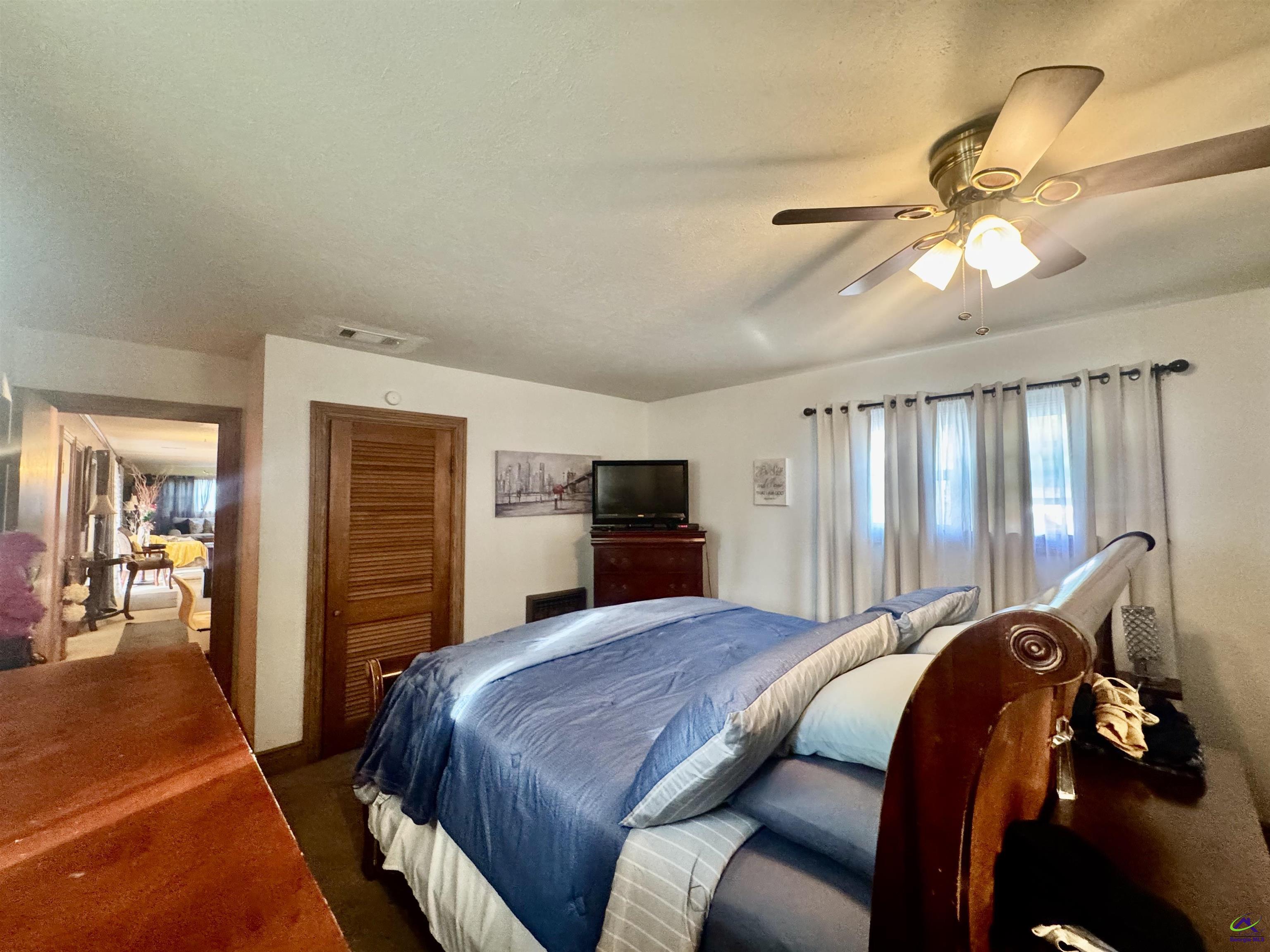 914 Adderton Street Americus, GA 31719 - Photo 28 of 53 a bedroom with a bed and a chandelier