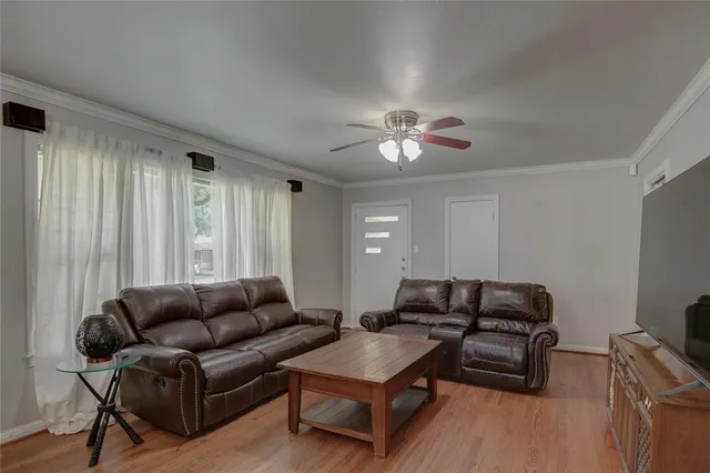 a living room with furniture a ceiling fan and a window