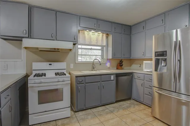 a kitchen with a stove sink and refrigerator