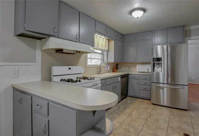 a kitchen with a sink appliances and cabinets
