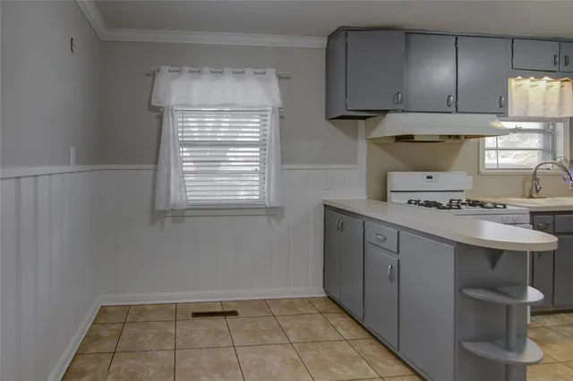 a kitchen with a sink cabinets and a window