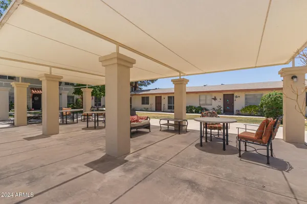 a view of a patio with table and chairs and floor to ceiling window