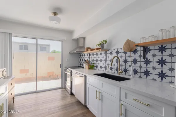 a kitchen with stainless steel appliances granite countertop a sink and wooden cabinets