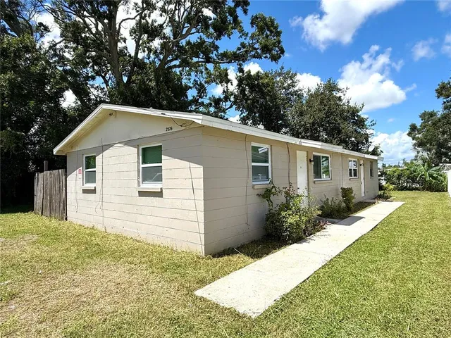 a front view of house with yard and trees around