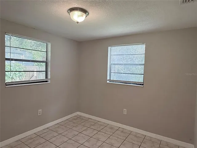 a view of an empty room with window and closet area