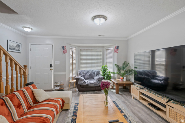962 Independence Avenue Provo, UT 84604 - Photo 2 of 31 Living area with a textured ceiling, ornamental molding, stairs, and wood finished floors
