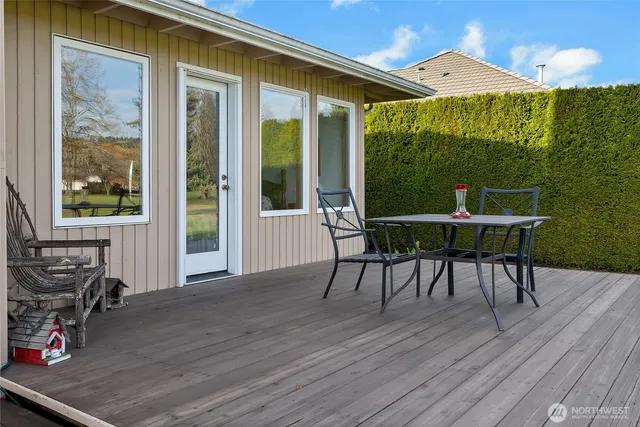 a view of an ocean with a table and chairs in patio