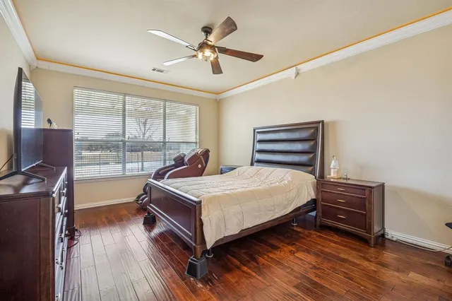 a bedroom with a bed and a flat tv screen on the dresser