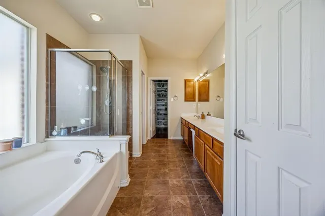 a bathroom with a tub sink and mirror