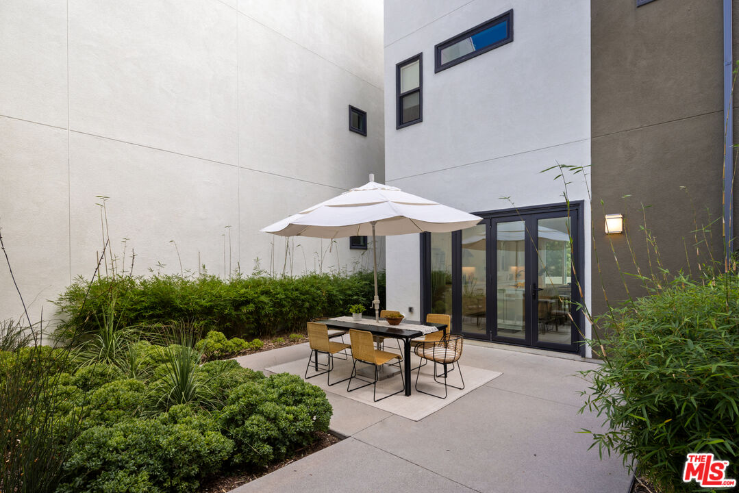 386 Novel Irvine, CA 92618 - Photo 33 of 52 a patio with a table and chairs under an umbrella
