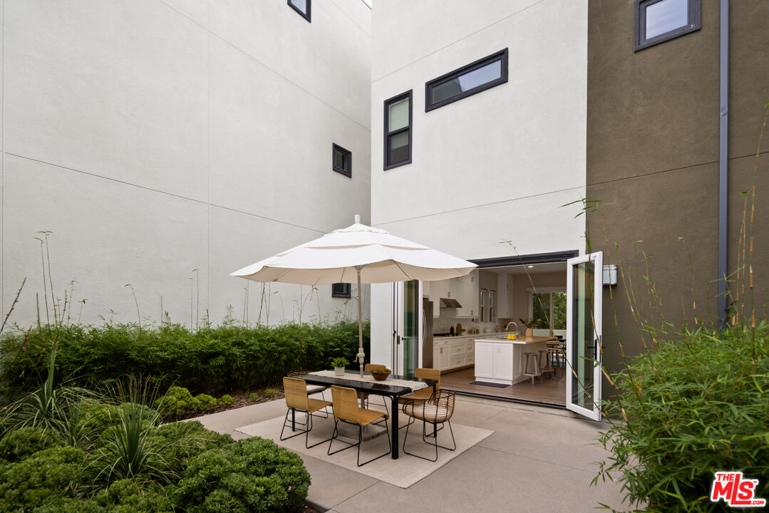 386 Novel Irvine, CA 92618 - Photo 34 of 52 a patio with a table and chairs under an umbrella