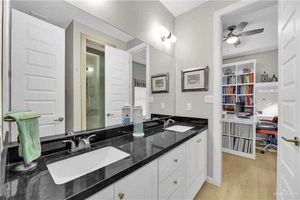 a bathroom with a granite countertop sink and a mirror