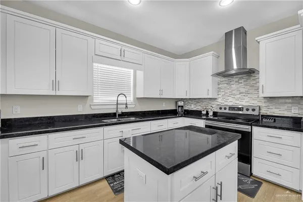 a kitchen with granite countertop white cabinets and white appliances