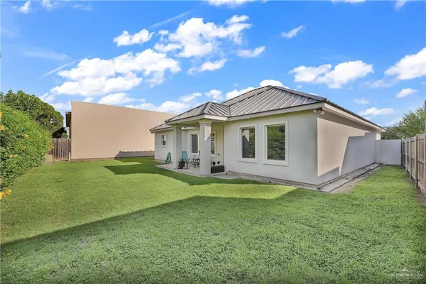 a view of a house with a yard potted plants and large tree