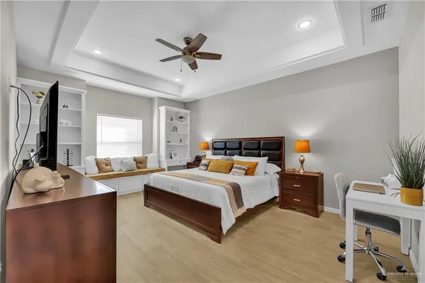 a bedroom with a bed a large window and potted plants on the dresser