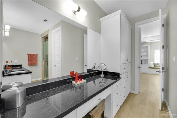 a bathroom with a granite countertop sink and a mirror