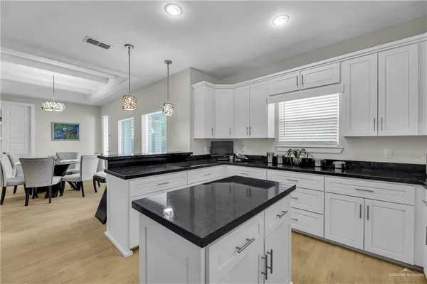 a kitchen with granite countertop a sink a counter top space appliances and cabinets