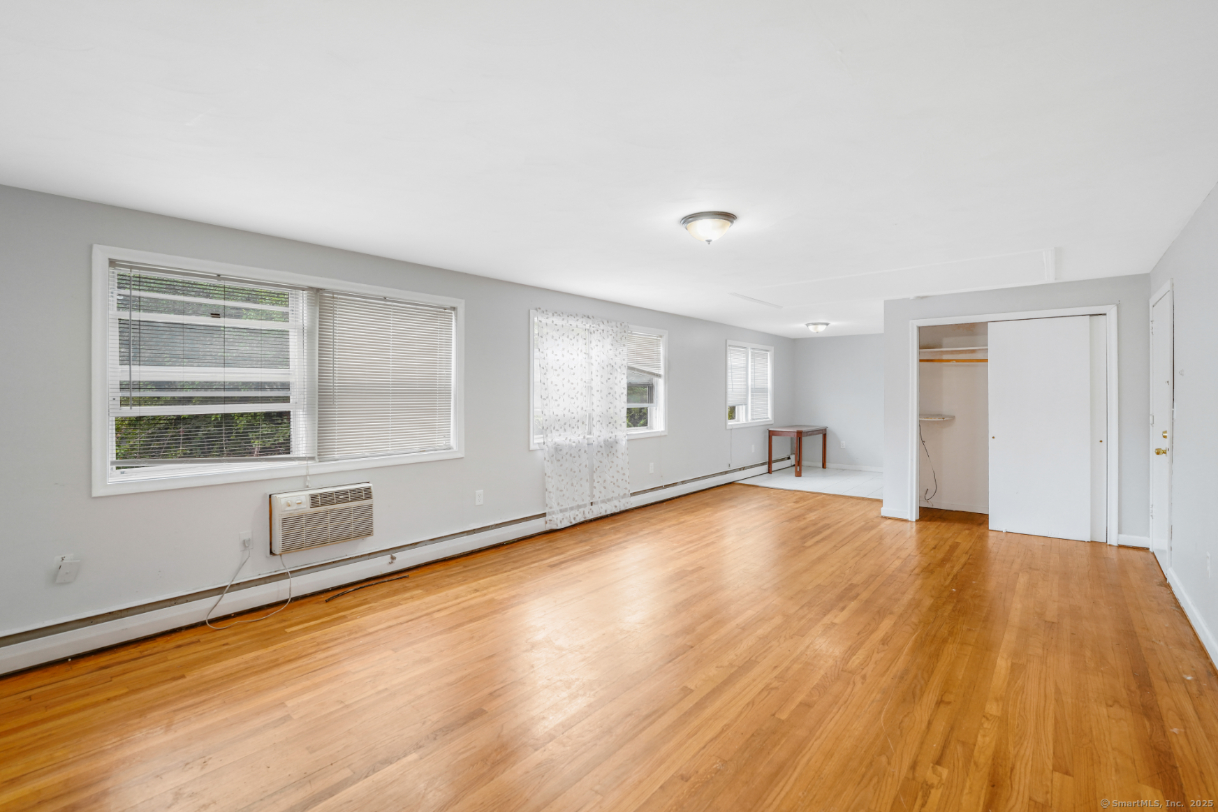 183 Barker Street, Unit A4 Hartford, CT 06114 - Photo 1 of 6 a view of an empty room with wooden floor and a window