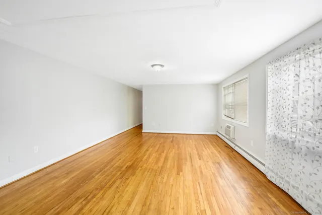 a view of a room with wooden floor and brick walls