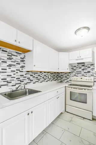 a kitchen with granite countertop white cabinets and white appliances