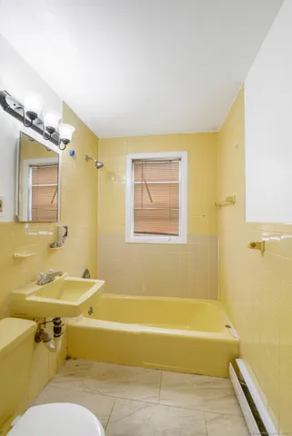 a bathroom with a sink mirror bathtub and toilet