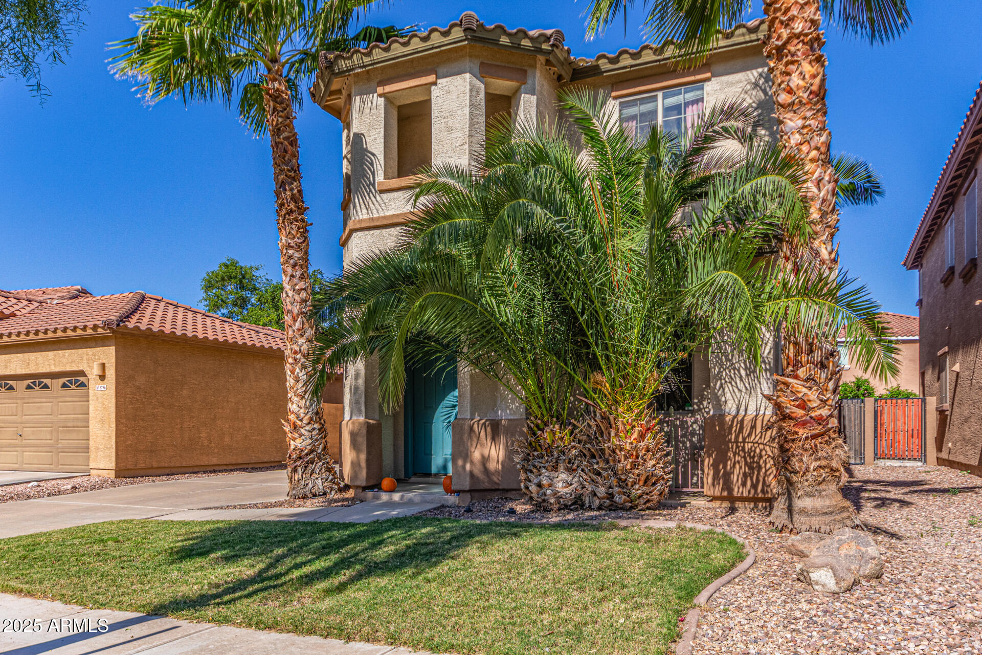 3802 East Chickadee Road Gilbert, AZ 85297 - Photo 2 of 29 a front view of a house with a yard and palm trees