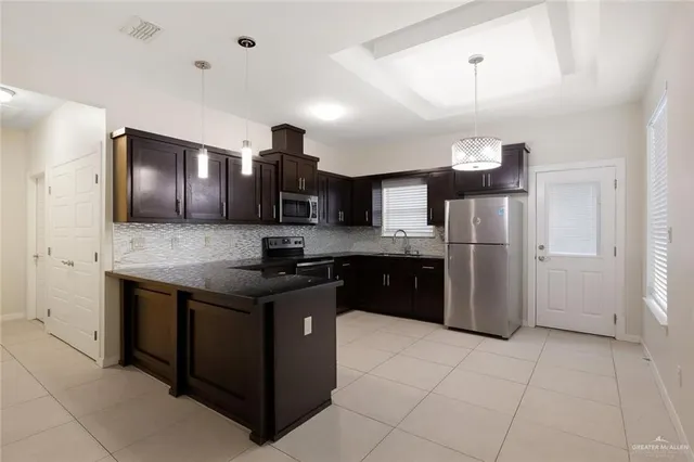 a kitchen with stainless steel appliances granite countertop a stove a refrigerator and a sink