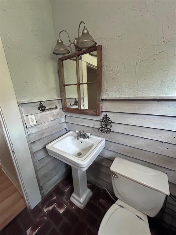 116 Gas Plant Road Doyline, LA 71023 - Photo 19 of 19 Pedestal sink with chrome fixtures, coordinating toilet, and brick-pattern flooring